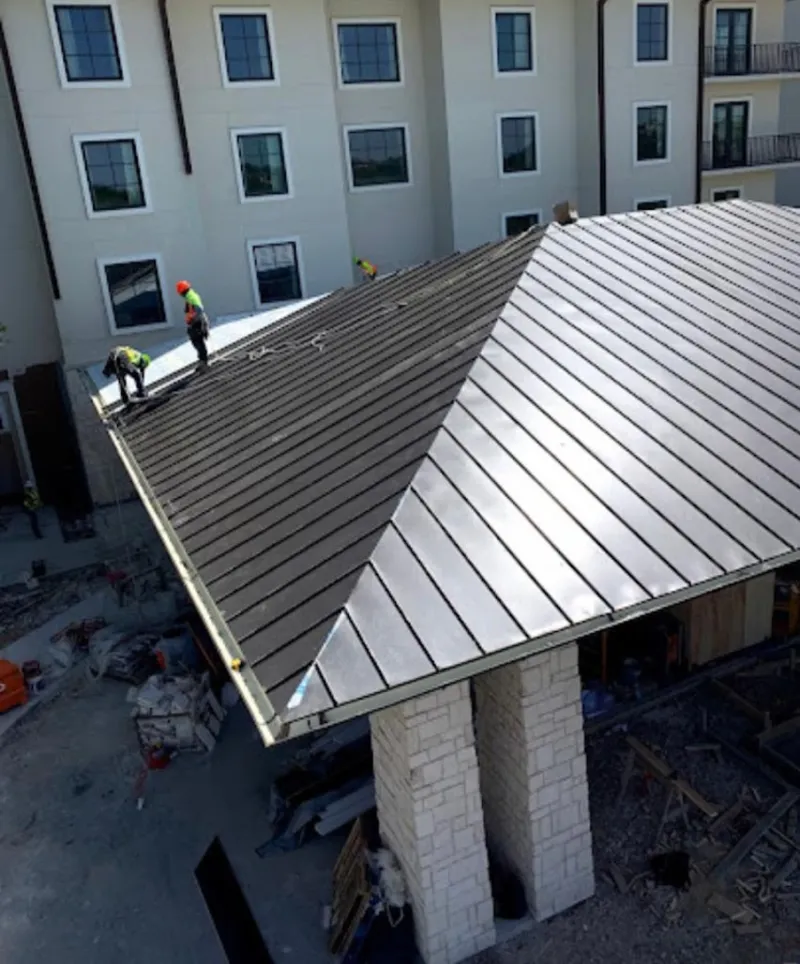 Crew installing standing seam metal roof panels on a commercial project in Rowland Heights